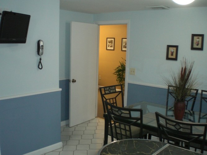 A room with a table and chairs and a door.