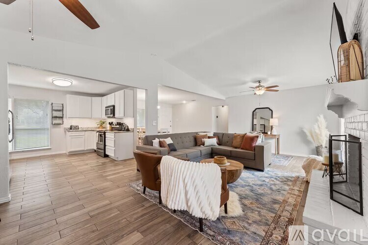 A living room with a brown sofa and a white rug.