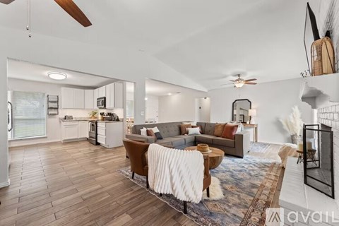 A living room with a brown sofa and a white rug.