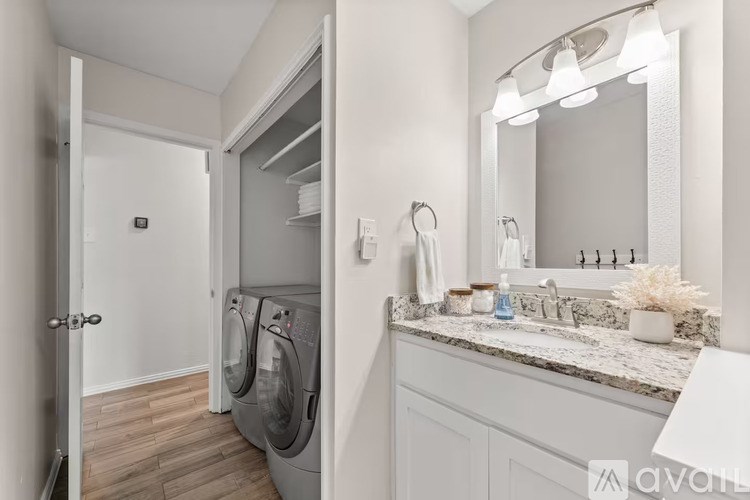 A modern bathroom with a washing machine in the doorway.