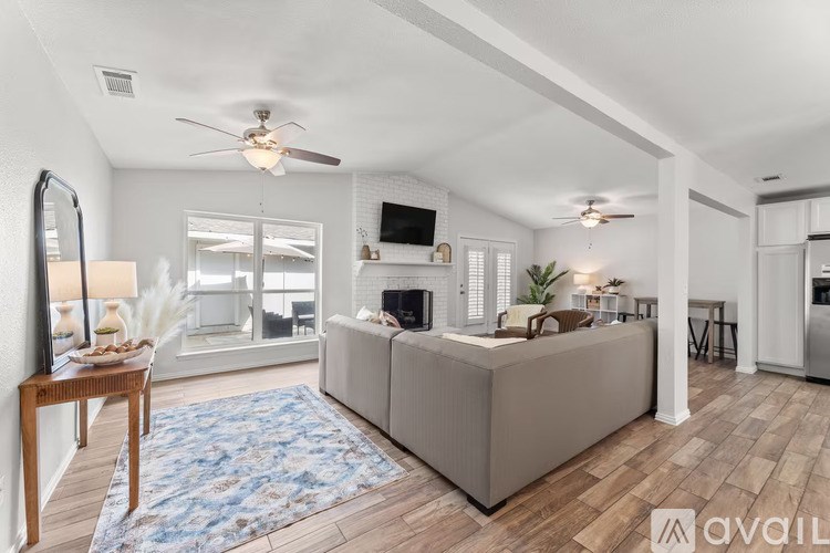A living room with a couch, a rug, and a television.