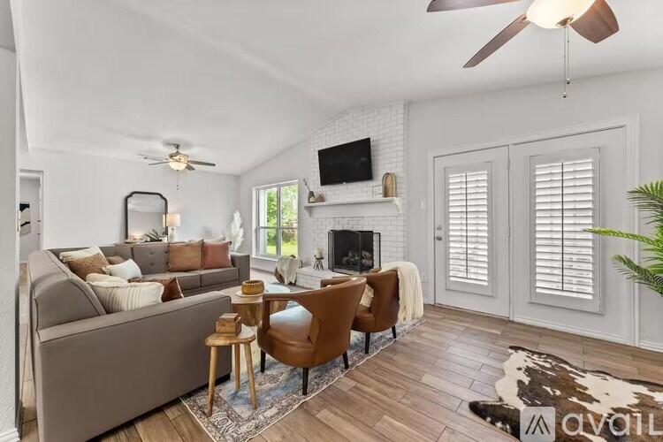 A living room with a grey couch, a fireplace, and a television.