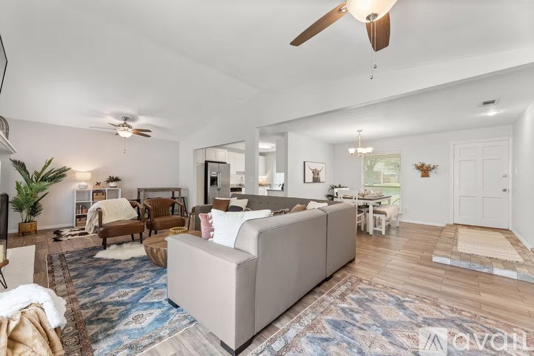 A living room with a white couch and a rug.