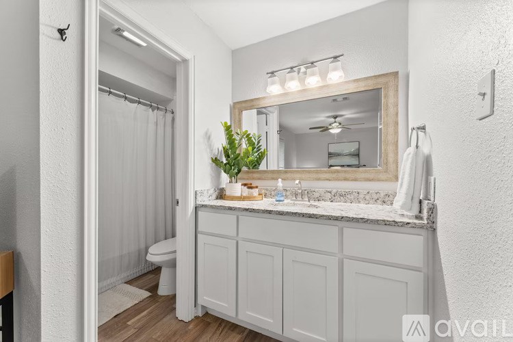 A bathroom with a white cabinet and a mirror above it.