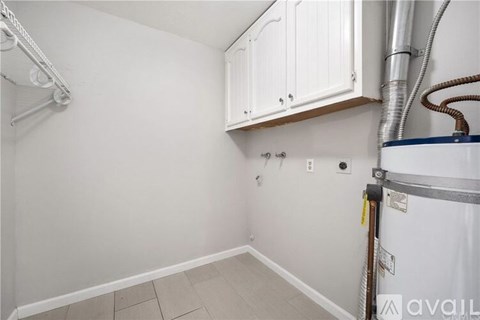 A kitchen area with white cabinets and a white refrigerator.
