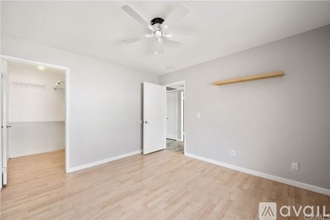 A room with a fan and a wooden beam on the wall.