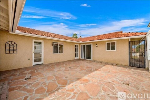 A house with a stone patio is for sale.
