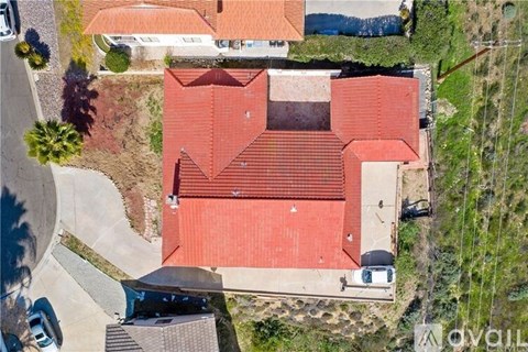 A red tiled roof of a building with a car parked in front.