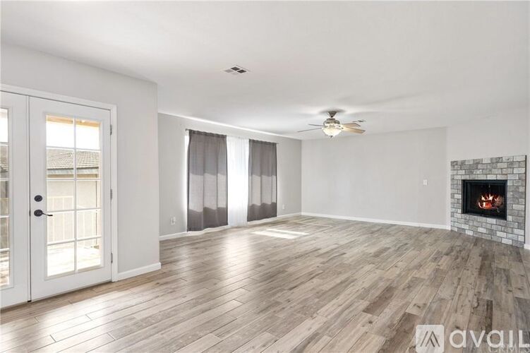 A spacious living room with a fireplace and hardwood flooring.