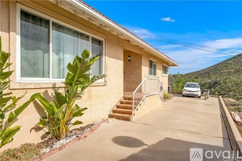 A house with a beige exterior and a white car parked in the driveway.
