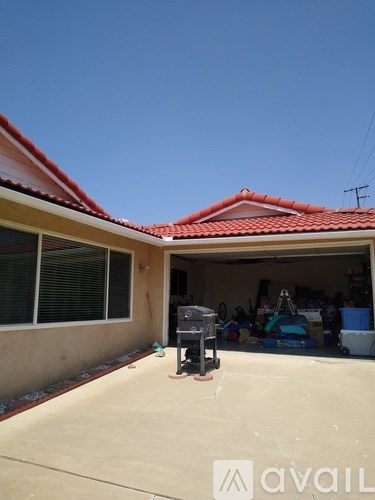 A house with a red roof and a garage full of items.