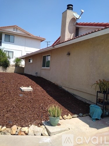 A house with a red tile roof and a satellite dish on the roof.