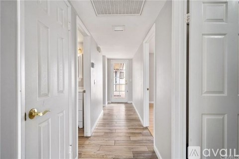A long hallway with white doors on both sides.