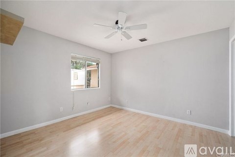 A room with a ceiling fan and a window.
