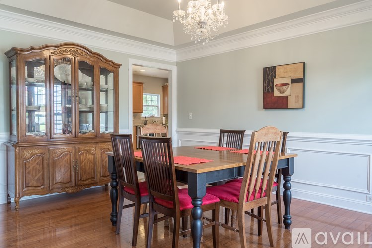 A wooden dining table with chairs and a chandelier in a room.
