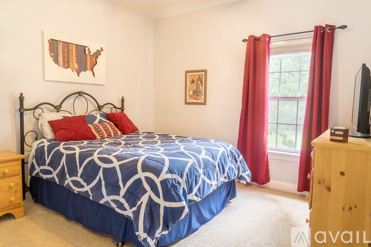 A bedroom with a bed, dresser, and window.