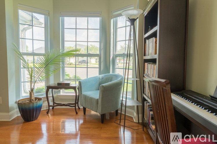A living room with a piano and a chair.