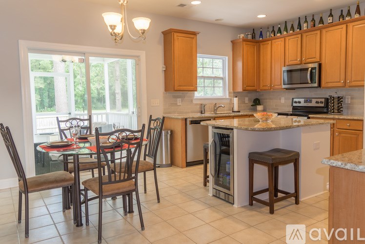 A kitchen with a table and chairs in front of a window.