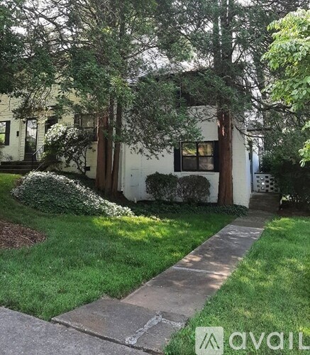 A white house with a green lawn in front.