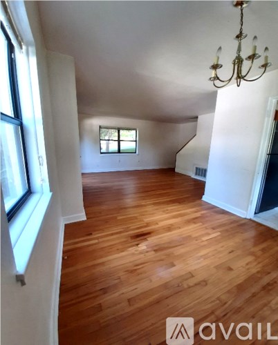 A room with wooden floors and a chandelier.