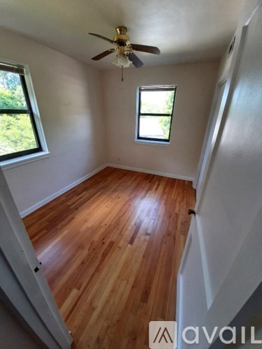 A room with wooden floors and a ceiling fan.