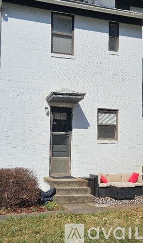 A white house with a black door and a small porch.