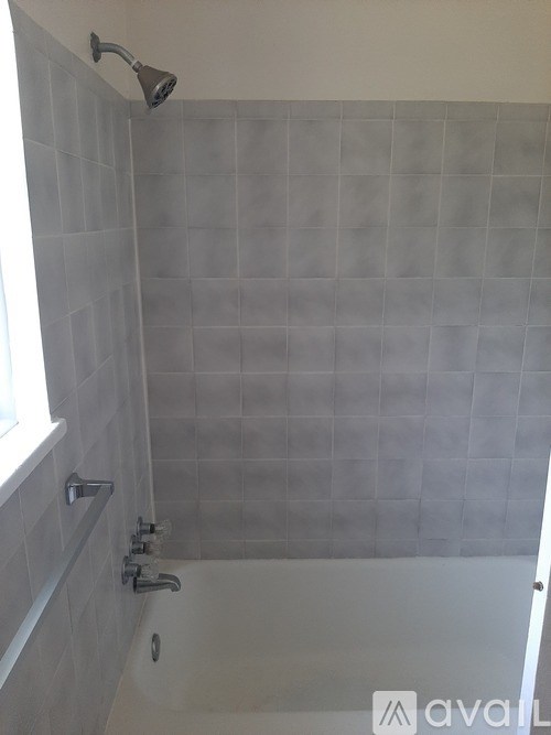 A shower area with a glass door and a window.