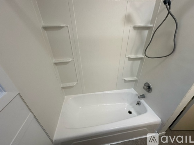 A white bathroom sink with a faucet and a hose.