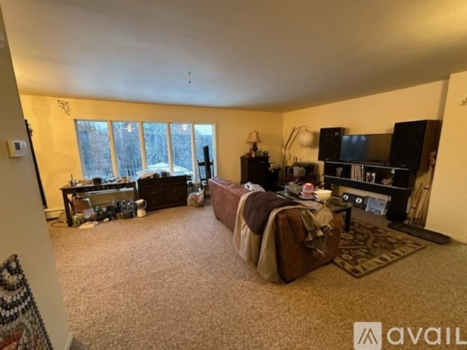 A living room with a couch, a coffee table, and a television.