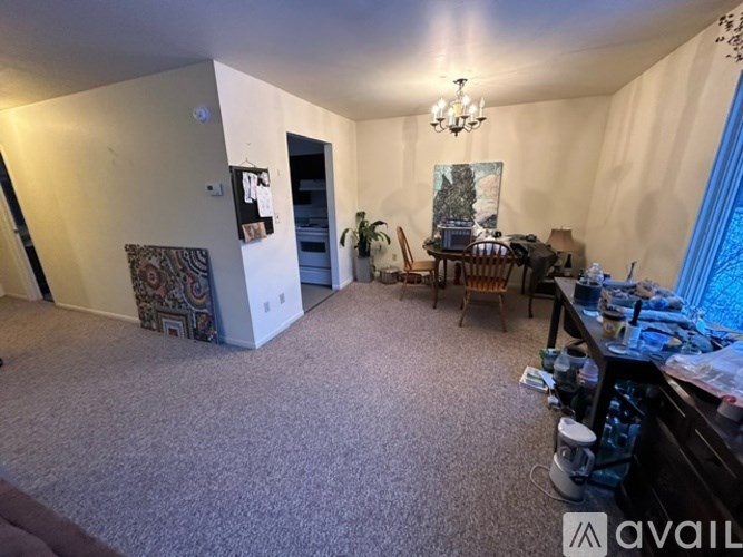 A room with a carpeted floor and a chandelier hanging from the ceiling.