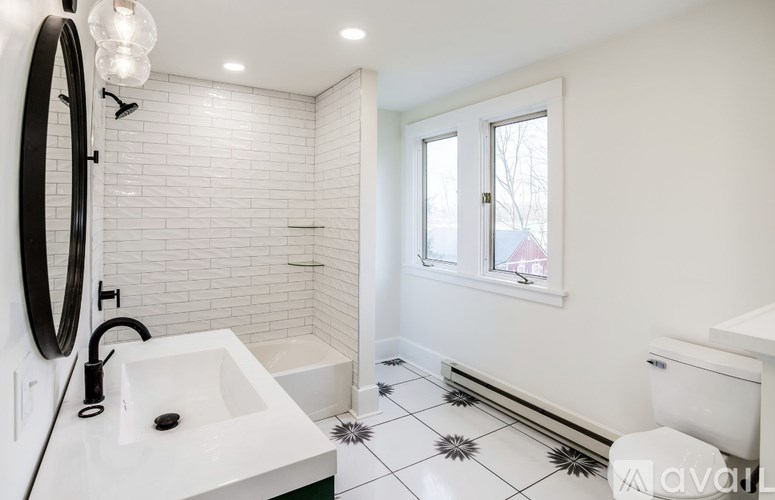 A bathroom with a white sink, toilet, and tiled floor.