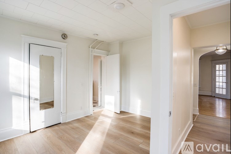 A spacious room with wooden floors and white walls.