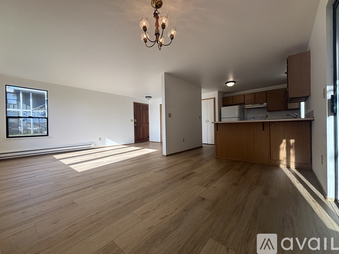 A large empty room with wooden floors and a chandelier.