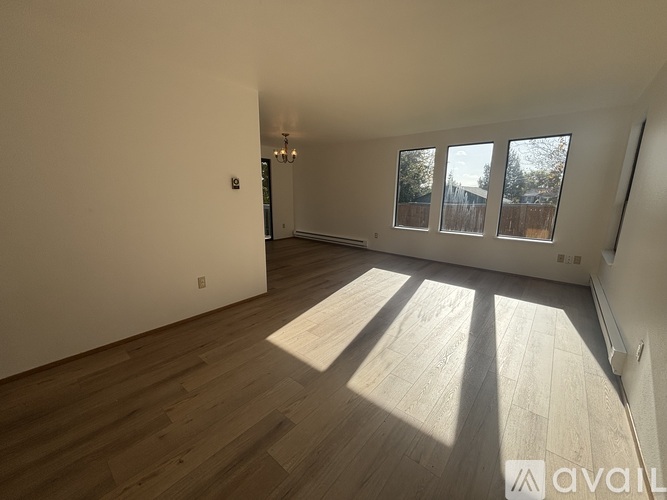 A room with wooden flooring and a chandelier is available for rent.