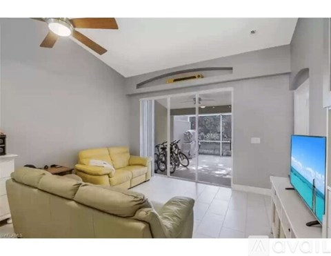 A living room with a yellow sofa and a television.