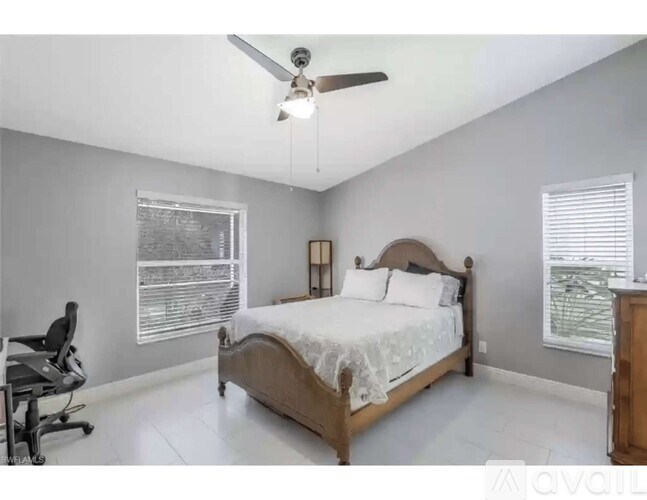 A bedroom with a bed, chair, and window.