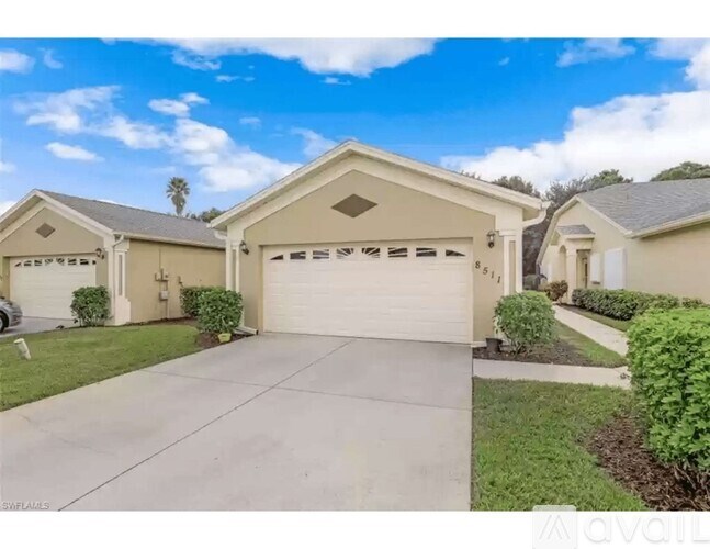 A house with a garage and a driveway in front of it.