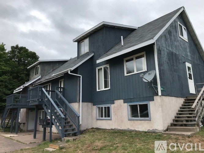 A two-story house with a balcony and stairs leading to the upper level.
