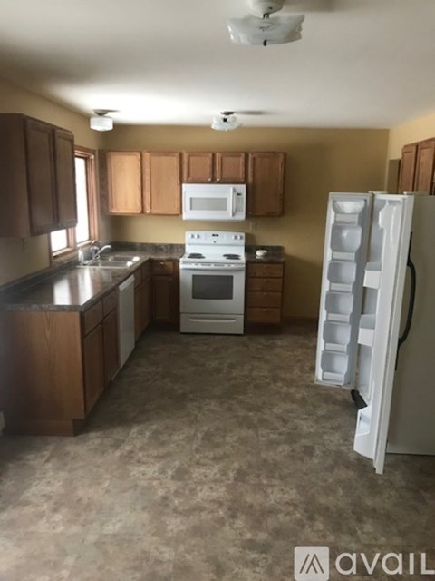 A kitchen with brown cabinets and a white refrigerator.