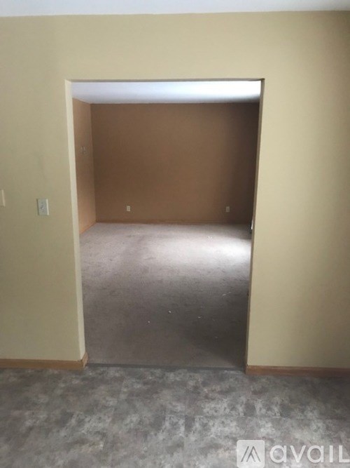 A room with a concrete floor and a doorway leading to another room.