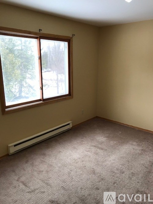 A room with a window and a radiator on the floor.