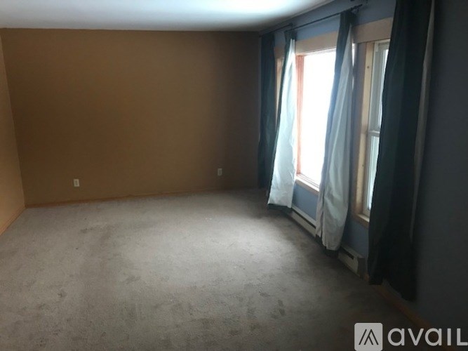 A room with a window and curtains.