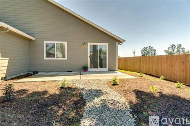 A house with a grey exterior and a gravel driveway in front.