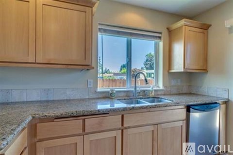 A kitchen with wooden cabinets and granite countertops.