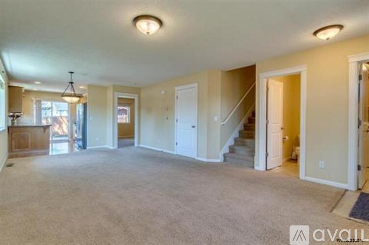 A spacious living room with a staircase leading to the upper floor.