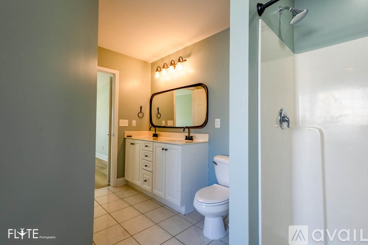 A bathroom with a white toilet, sink, and mirror.