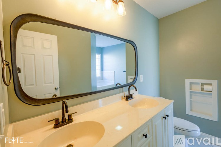 A bathroom with a sink, mirror, and toilet.