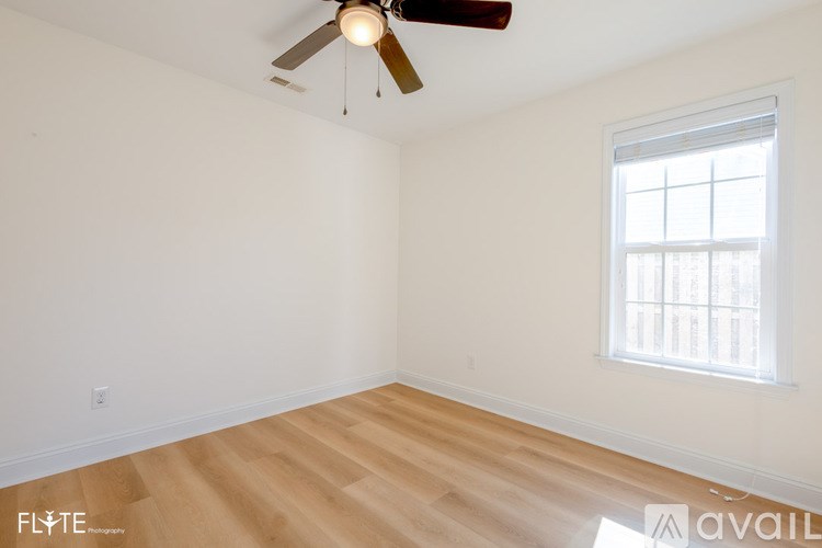 A room with a ceiling fan and a window.