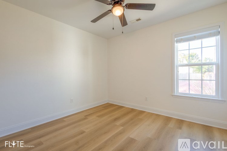 A room with a ceiling fan and a window.