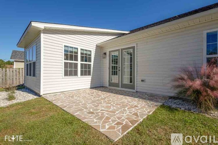 A house with a grey front and a stone pathway leading to the door.